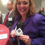 Monica holding Women of Influence Award in 2016