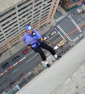 Photo of Monica Gould rappelling down wall