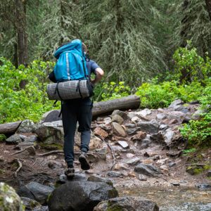 man hiking in the woods with backpack