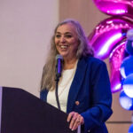 Monica Gould speaking at podium