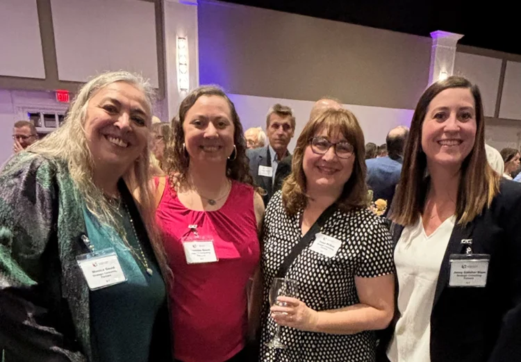 Monica Gould and employees posing at event